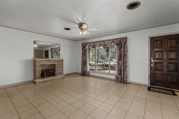 a view of an empty room with a fireplace and a window