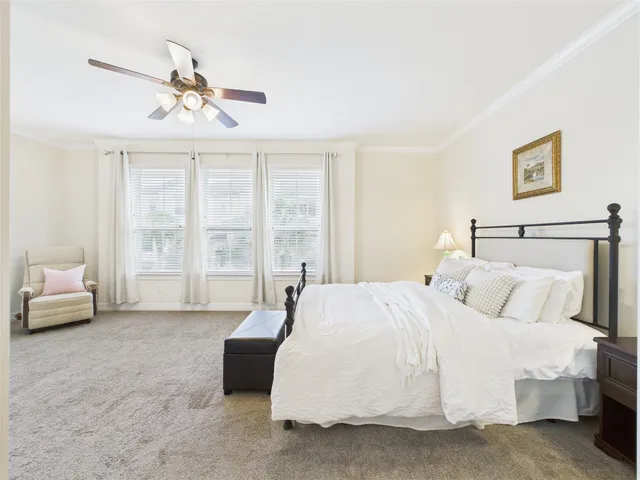 a bedroom with a large bed and a chandelier