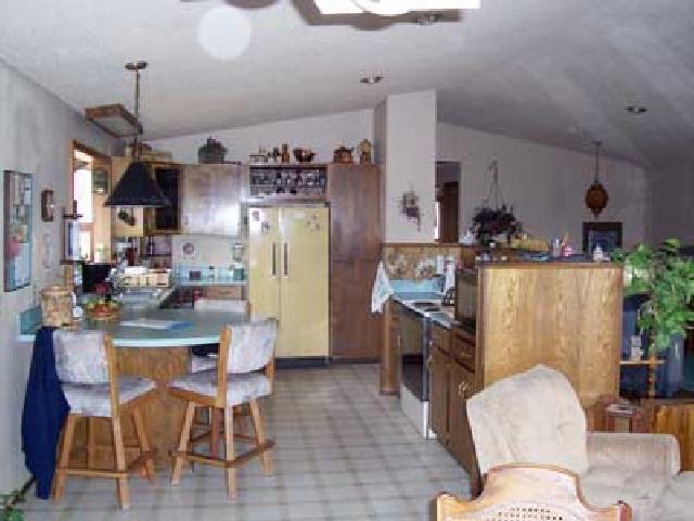9450 Bittner Road Yakima, WA 98901 - Photo 4 of 9 a kitchen with stainless steel appliances granite countertop a refrigerator a stove a sink dishwasher and a dining table with wooden floor