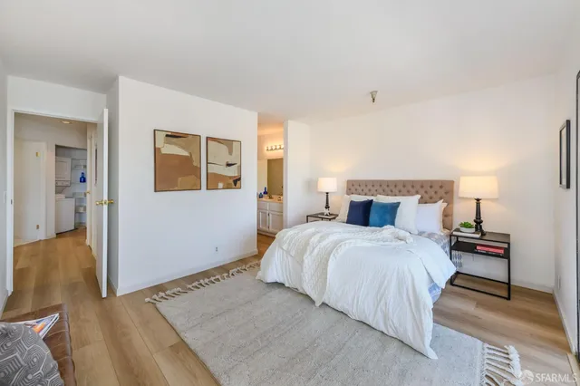 a bedroom with a bed and wooden floor