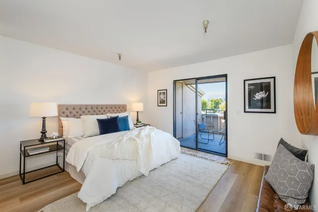 a bedroom with a bed a mirror and a large window