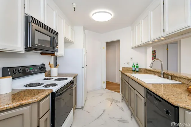 a kitchen with stainless steel appliances granite countertop a sink stove and microwave