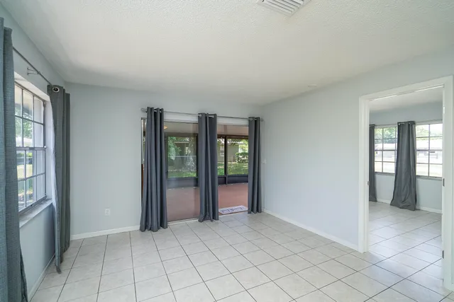 an empty room with entrance and windows