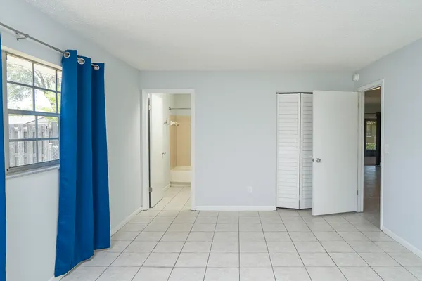 an empty room with windows and closet