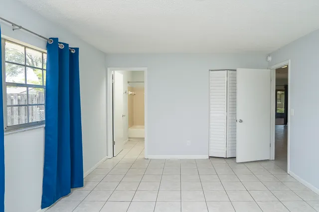 an empty room with windows and closet