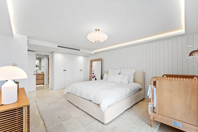 a bedroom with a bed and a refrigerator