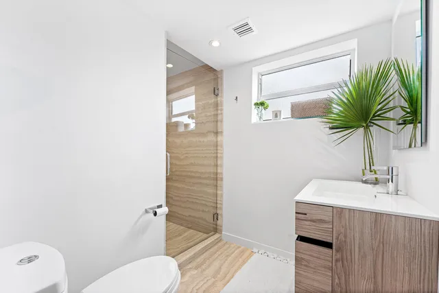 a bathroom with a sink a toilet and shower