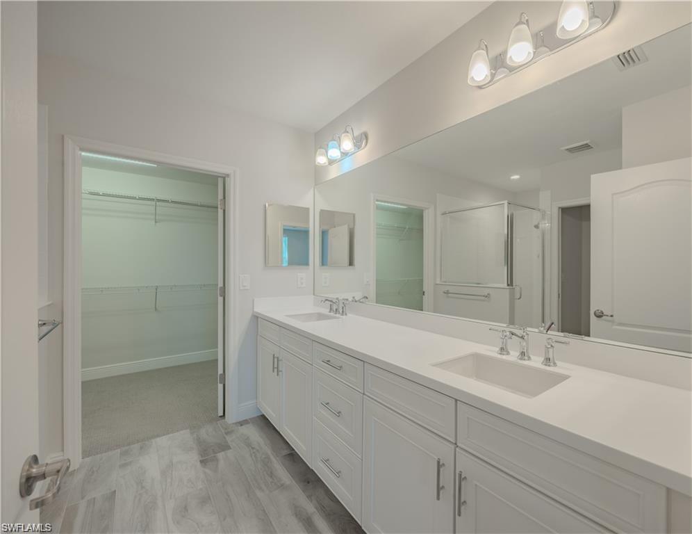 2335 Sawyers Hill Road, Unit 503 Naples, FL 34120 - Photo 11 of 23 a bathroom with double sink and a mirror