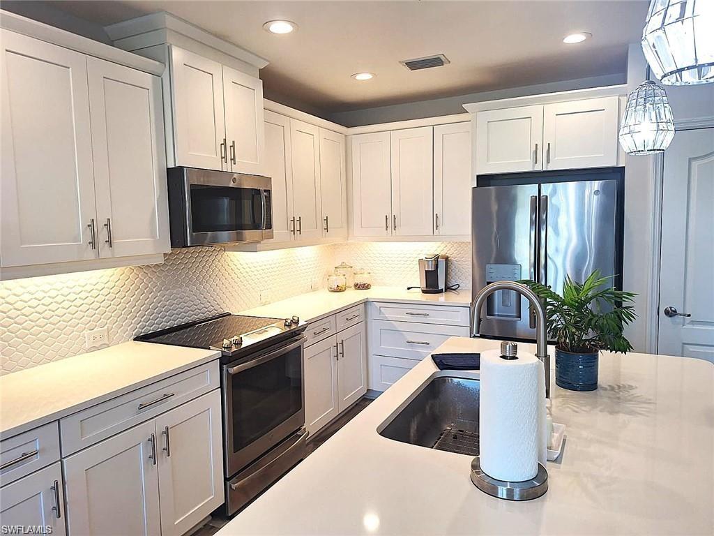 2335 Sawyers Hill Road, Unit 503 Naples, FL 34120 - Photo 3 of 23 a kitchen with a sink a stove and refrigerator