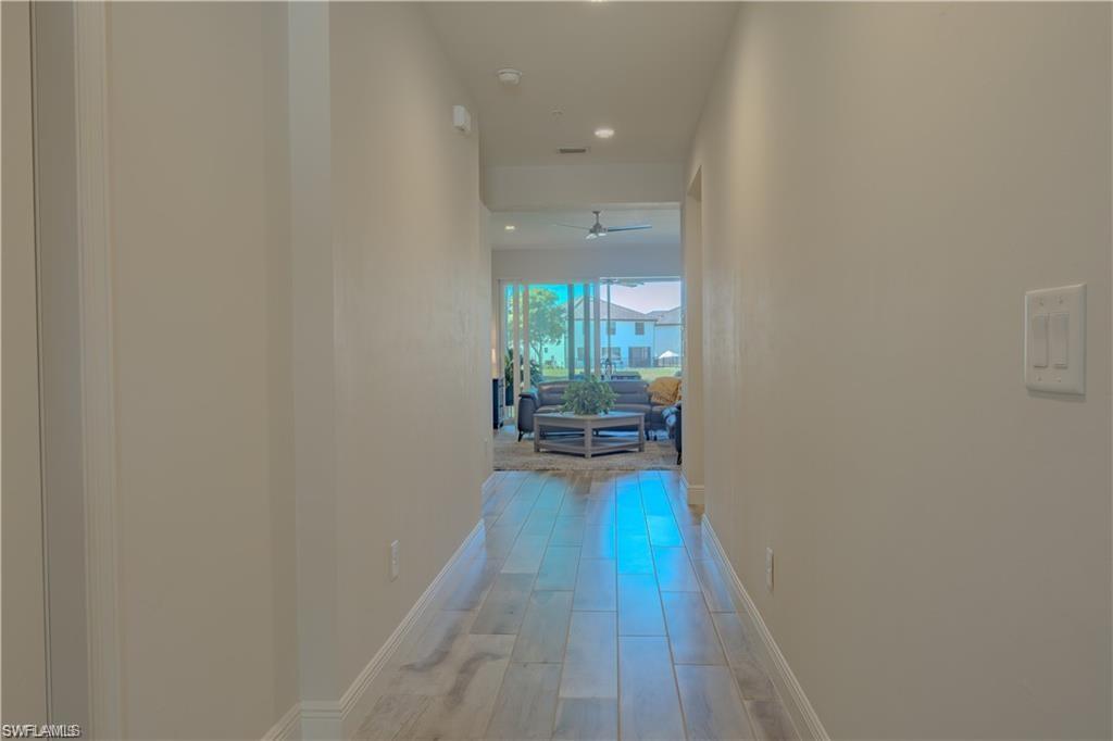 2335 Sawyers Hill Road, Unit 503 Naples, FL 34120 - Photo 6 of 23 a view of a hallway with wooden floor and a fireplace