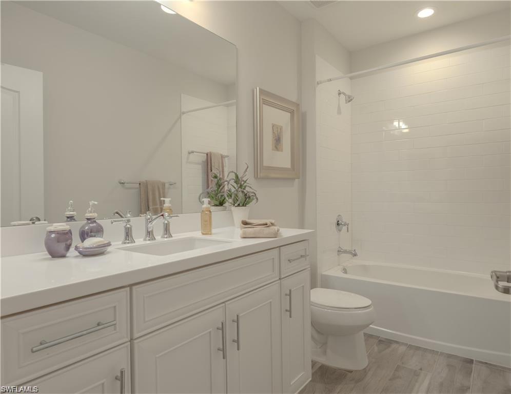 2335 Sawyers Hill Road, Unit 503 Naples, FL 34120 - Photo 10 of 23 a bathroom with a granite countertop sink a toilet and a bathtub