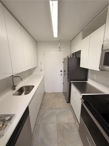 a kitchen with a sink stove and refrigerator