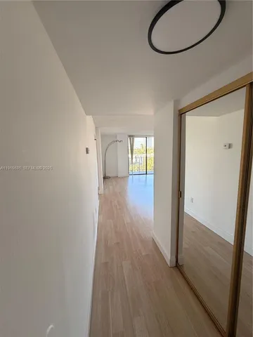 a view of a room with wooden floor and glass door