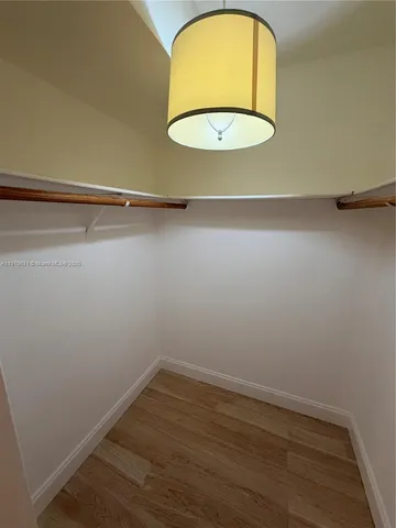 an empty room with a wooden floor and a window