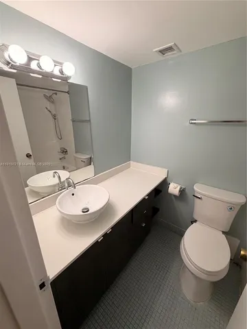 a bathroom with a sink a toilet a mirror and vanity
