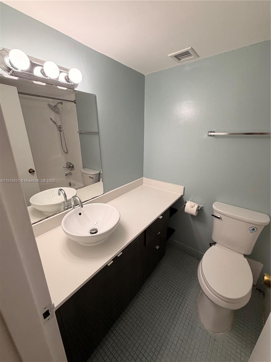 2350 Northeast 135th Street, Unit 503 North Miami, FL 33181 - Photo 8 of 9 a bathroom with a sink a toilet a mirror and vanity