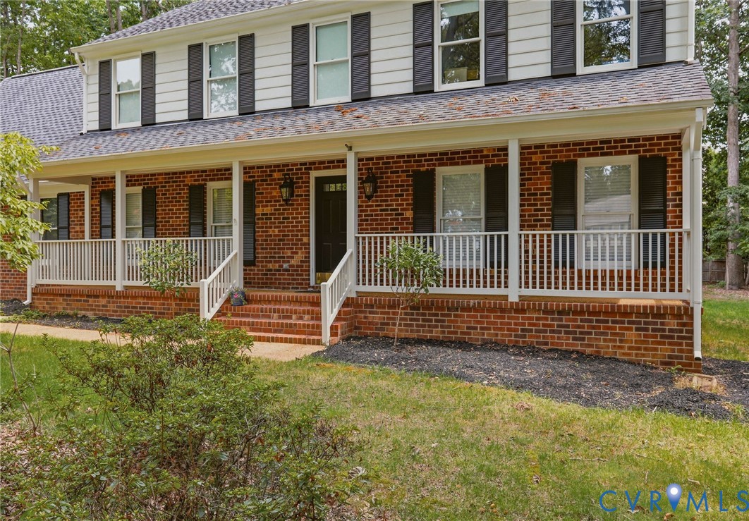 Brick facade home featuring a covered front porch,