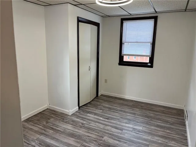 an empty room with wooden floor and closet