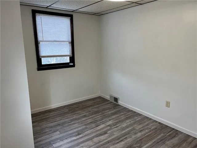 a view of a small space with wooden floor and a window