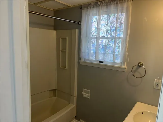 a bathroom with a granite countertop bathtub shower and a sink
