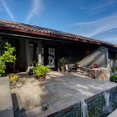 a view of a house with potted plants and furniture