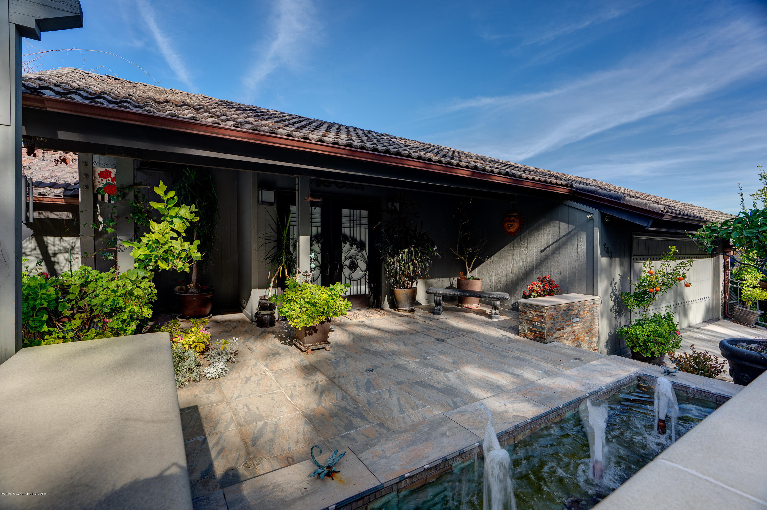 a view of a house with potted plants and furniture