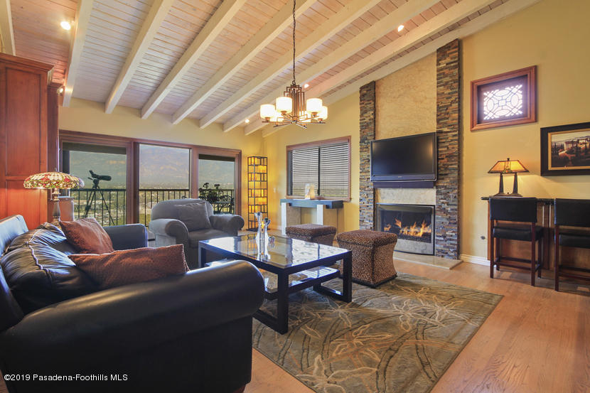943 Glen Oaks Boulevard Pasadena, CA 91105 - Photo 13 of 38 a living room with furniture a fireplace and a flat screen tv