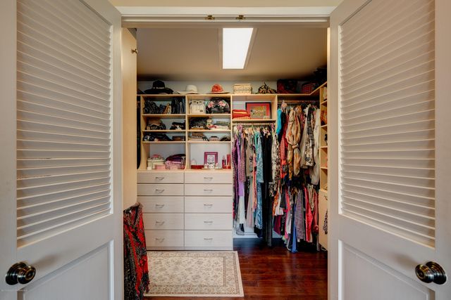 a view of walk in closet with clothes and shoes