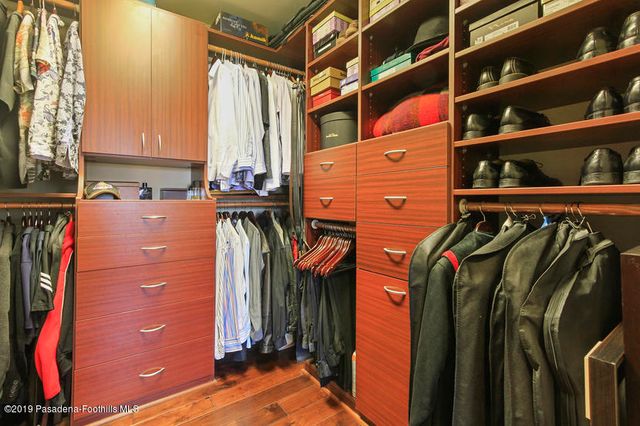 a view of walk in closet with clothes and shoes