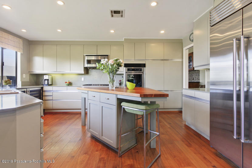 943 Glen Oaks Boulevard Pasadena, CA 91105 - Photo 5 of 38 a kitchen with granite countertop a sink cabinets stainless steel appliances and a center island