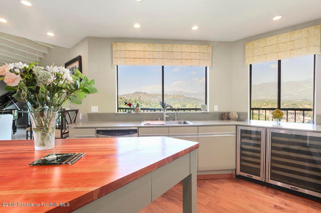 a view of a kitchen with kitchen island a large window cabinets and living room