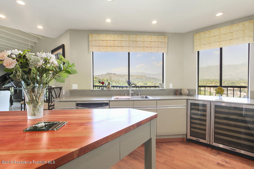 943 Glen Oaks Boulevard Pasadena, CA 91105 - Photo 6 of 38 a view of a kitchen with kitchen island a large window cabinets and living room
