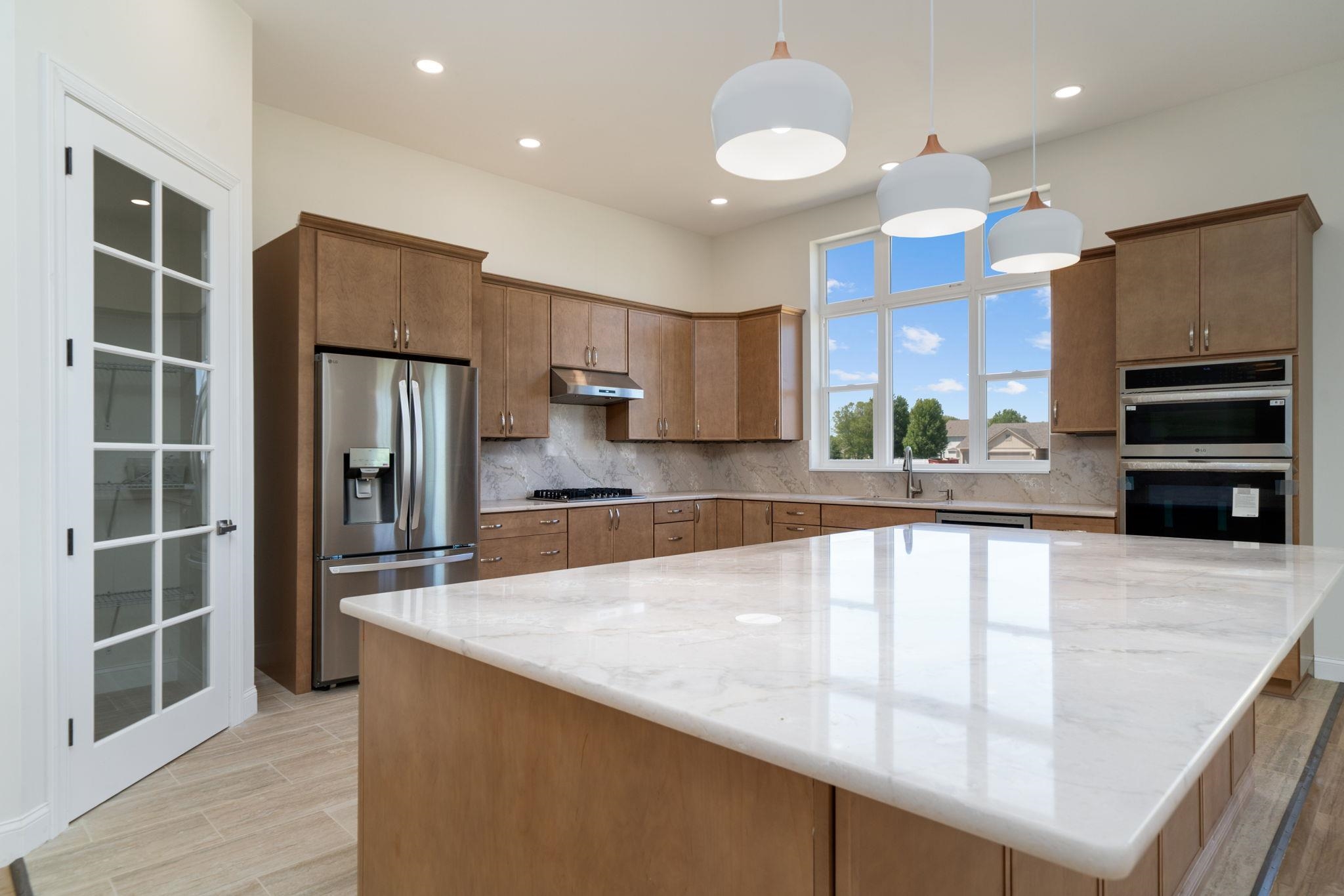 5145 Sycamore Ridge Road Belvidere, IL 61008 - Photo 13 of 57 a large kitchen with stainless steel appliances a large counter top a stove and a refrigerator