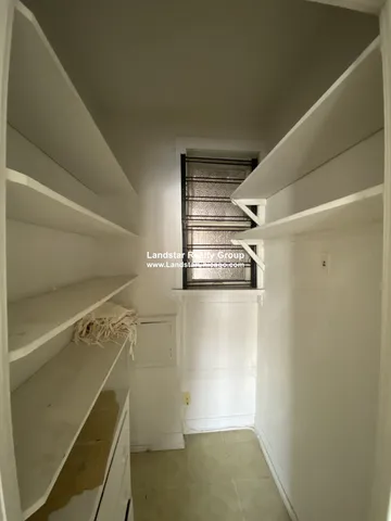 a view of walk in closet with clothes