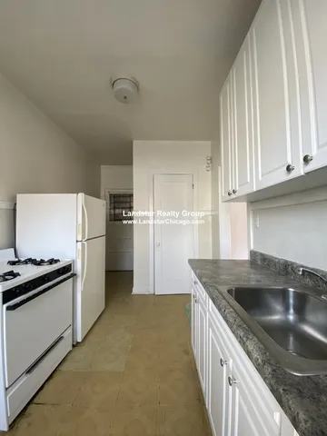 a kitchen that has a sink stainless steel appliances a stove and a refrigerator