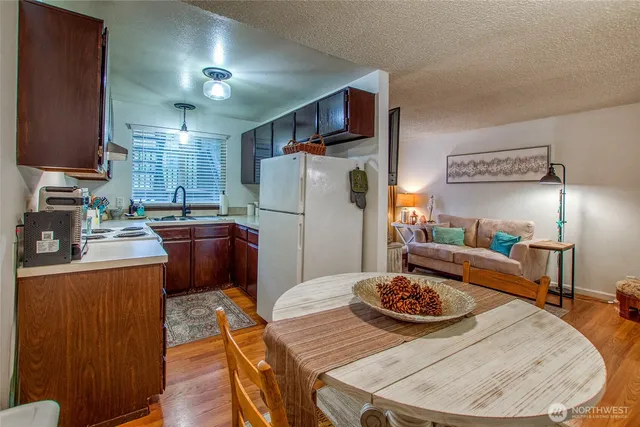 a kitchen with a refrigerator and wooden floor