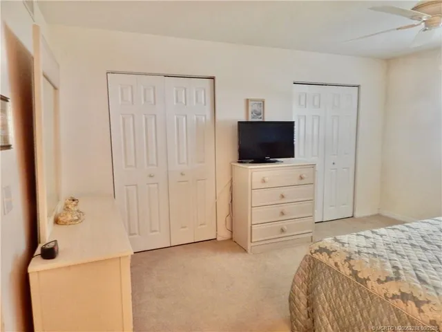 a bedroom with a bed and a flat tv screen on dresser