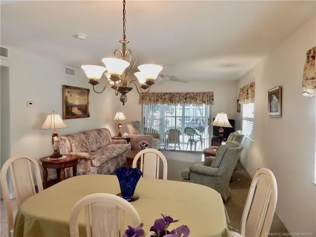 a dining room with furniture a large window and a chandelier