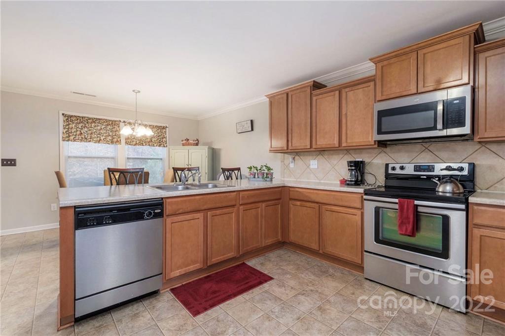 5846 Ringneck Road Charlotte, NC 28216 - Photo 9 of 28 a kitchen with stainless steel appliances granite countertop a stove a sink and a microwave