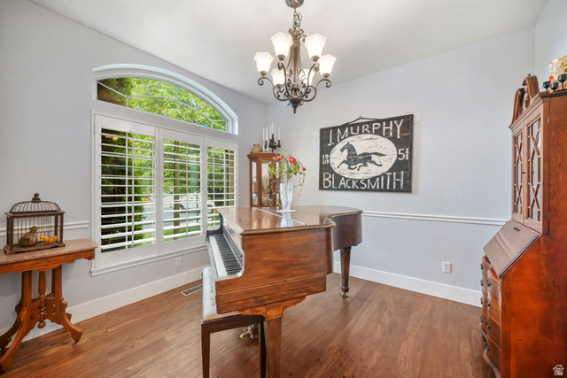 357 South 320 W Street Lindon, UT 84042 - Photo 9 of 41 Room featuring wood-finish flooring, a decorative chandelier, and a large window with plantation shutters and an arched transom