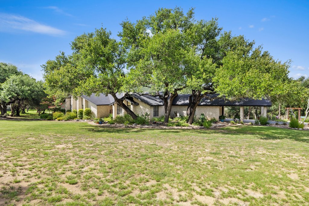 23644 Nameless Road Leander, TX 78641 - Photo 3 of 40 Mature trees frame this charming residence, offering natural shade and a sense of established tranquility.
