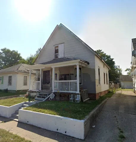 a view of a house with backyard and sitting area