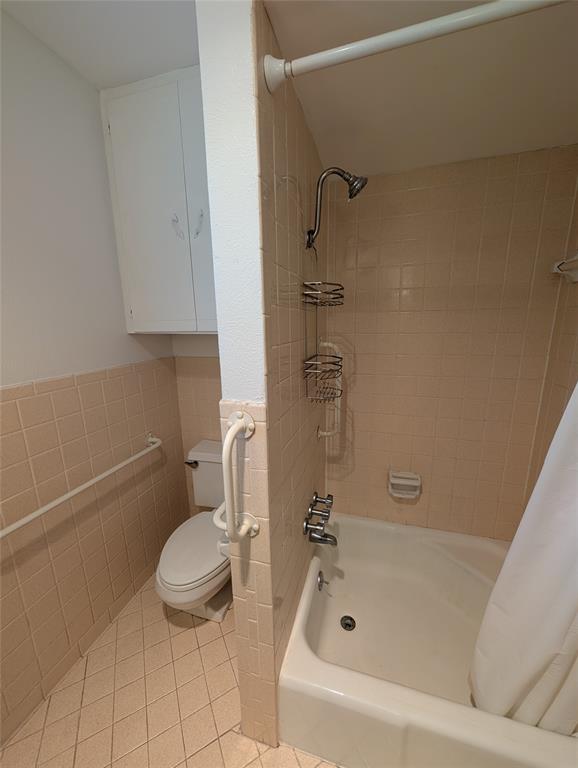 4715 Skillman Street, Unit A Dallas, TX 75206 - Photo 25 of 28 Bathroom featuring a white bathtub, ceramic tile walls, and a built-in storage cabinet