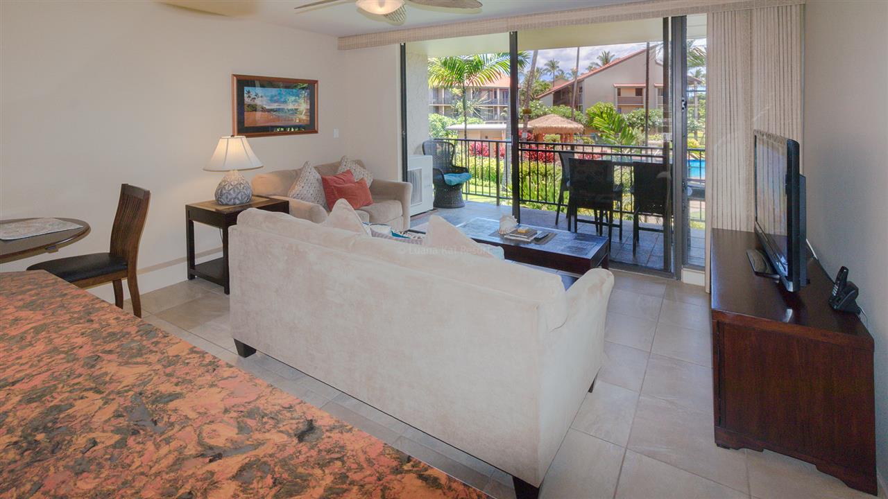 940 South Kihei Road, Unit B212 Kihei, HI 96753 - Photo 6 of 22 a living room with furniture a flat screen tv and a floor to ceiling window