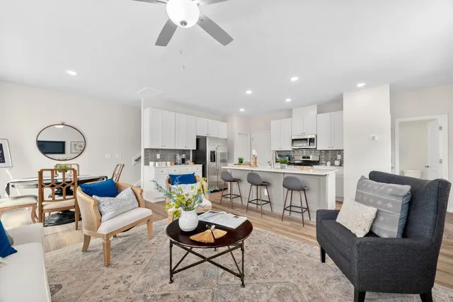 a living room with furniture kitchen view and a chandelier