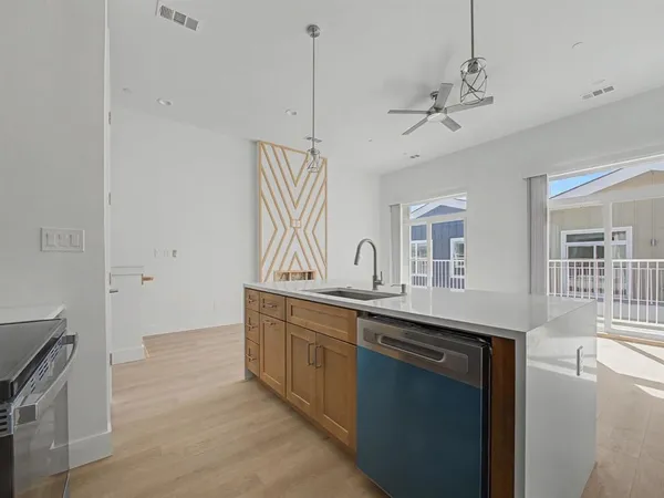 a kitchen with stainless steel appliances granite countertop a sink a stove and a wooden floors