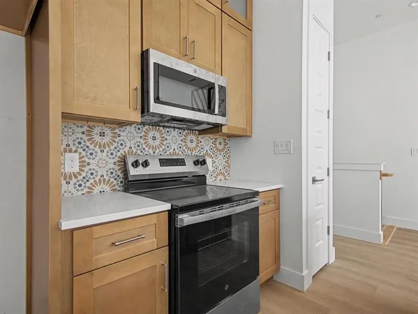 a kitchen with stainless steel appliances granite countertop white cabinets stove and microwave