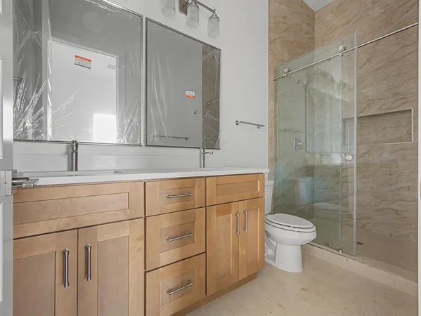 a bathroom with a sink toilet a mirror and shower
