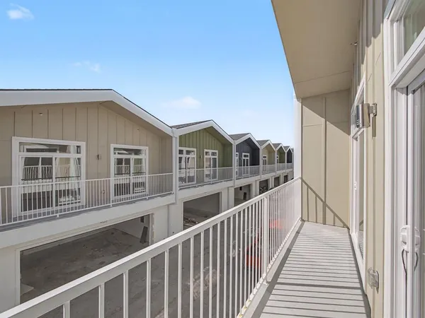 a view of a house with large windows and wooden fence