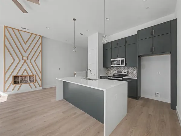 a kitchen with stainless steel appliances a sink a stove a refrigerator and cabinets